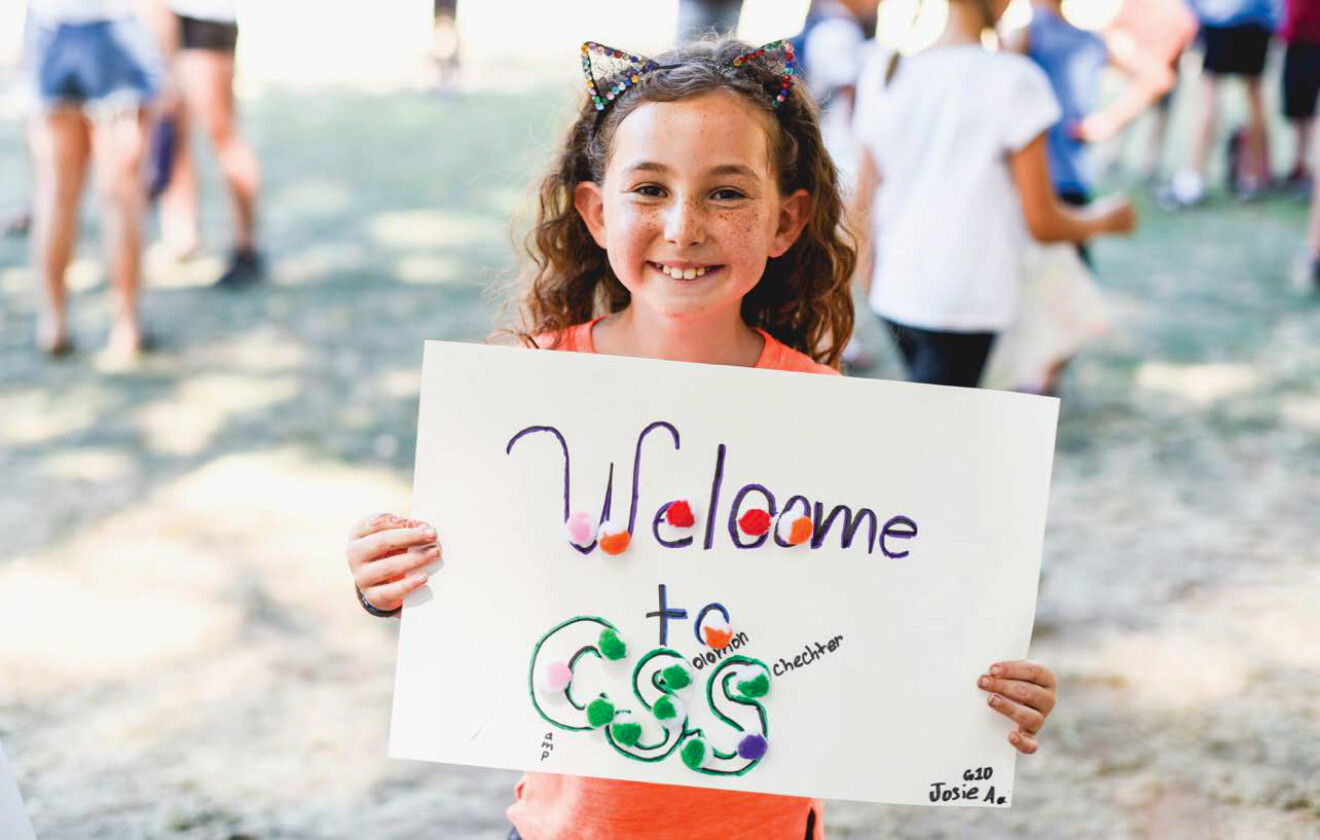 girl holding sign that says welcome to css.