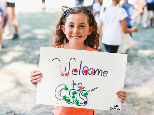 girl holding sign that says welcome to css.