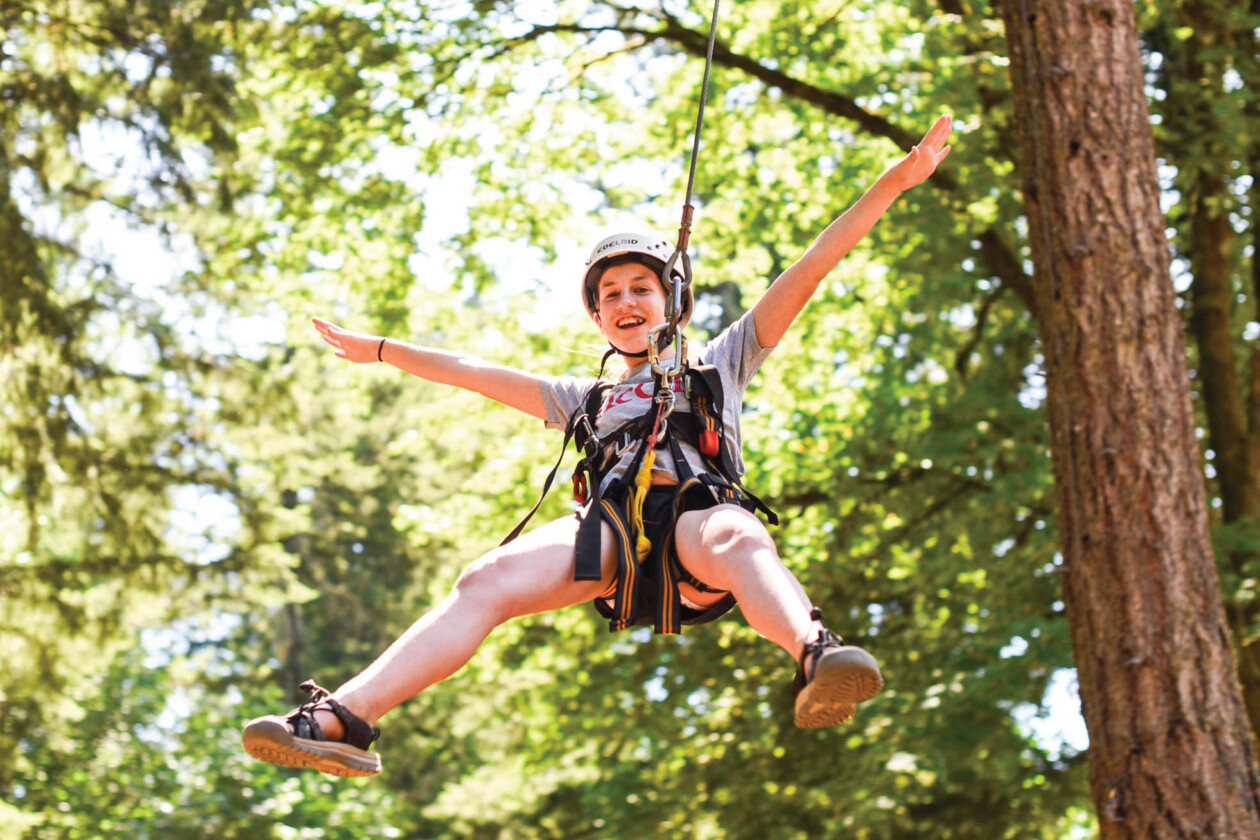 kid zip lining in the trees.