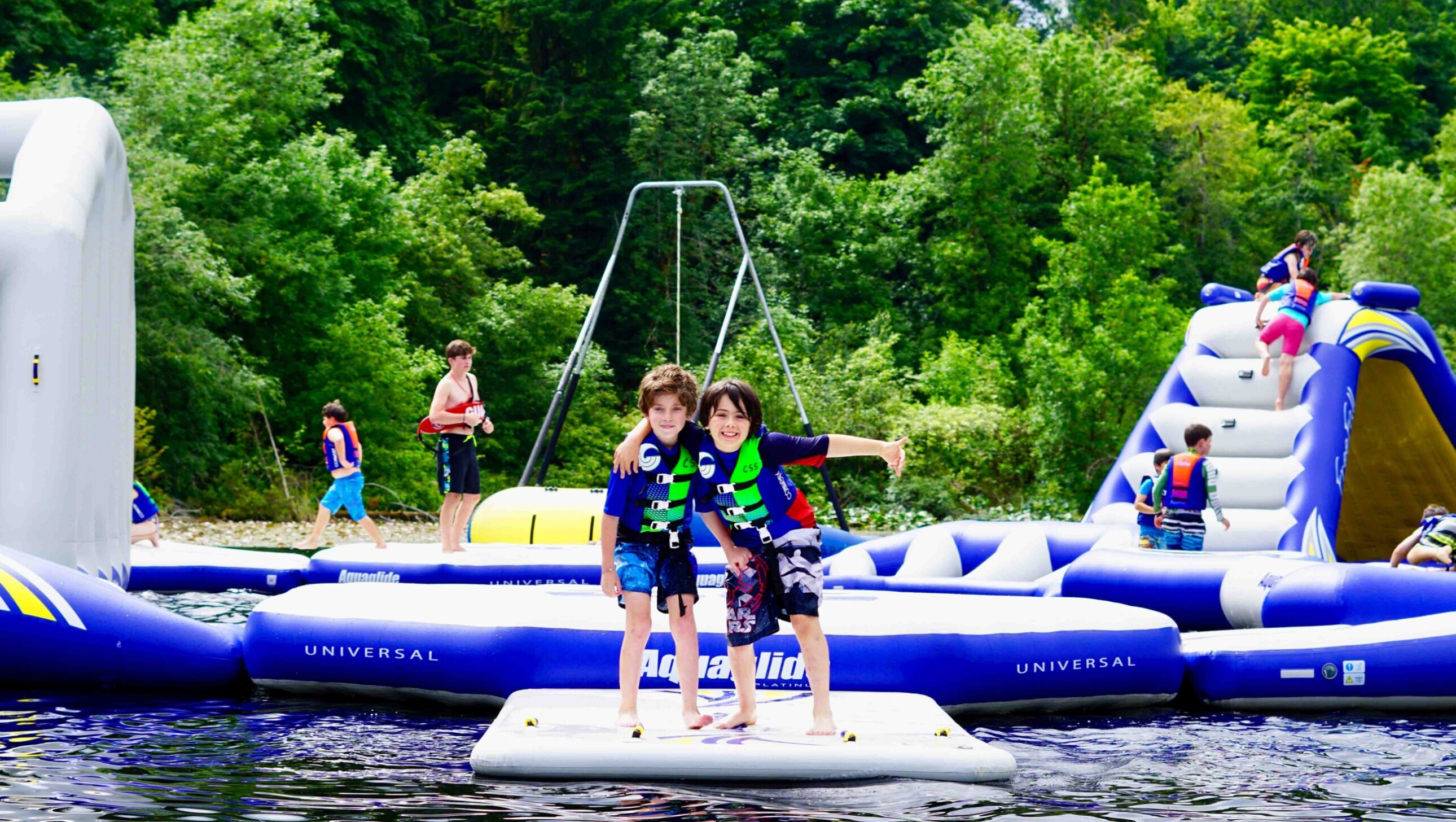 boys standing on a lake inflatable.