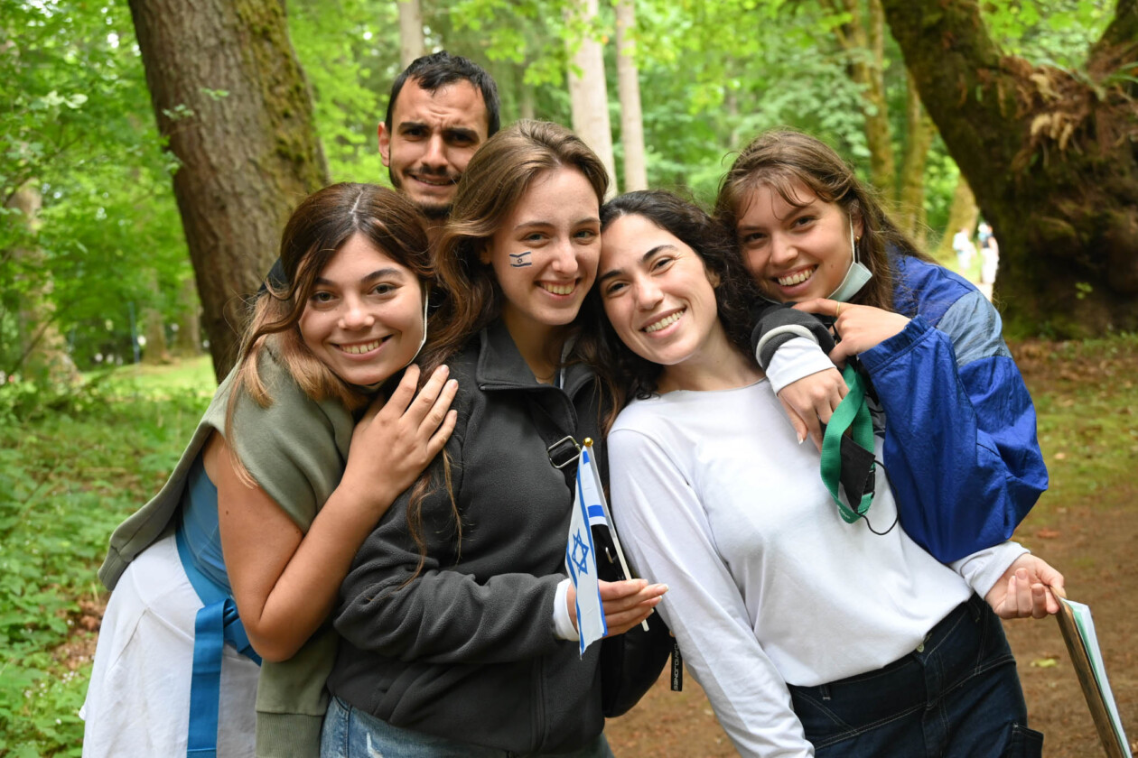 camp counselor smiling in a forest.