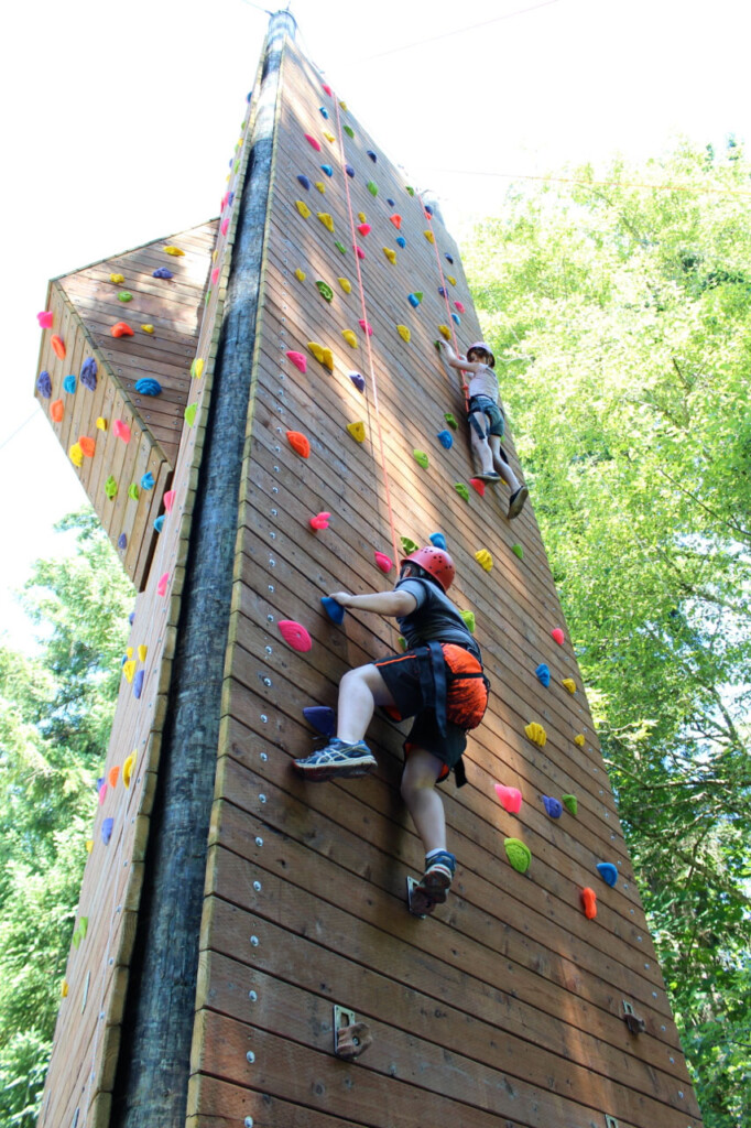 two kids climbing a climbing tower.