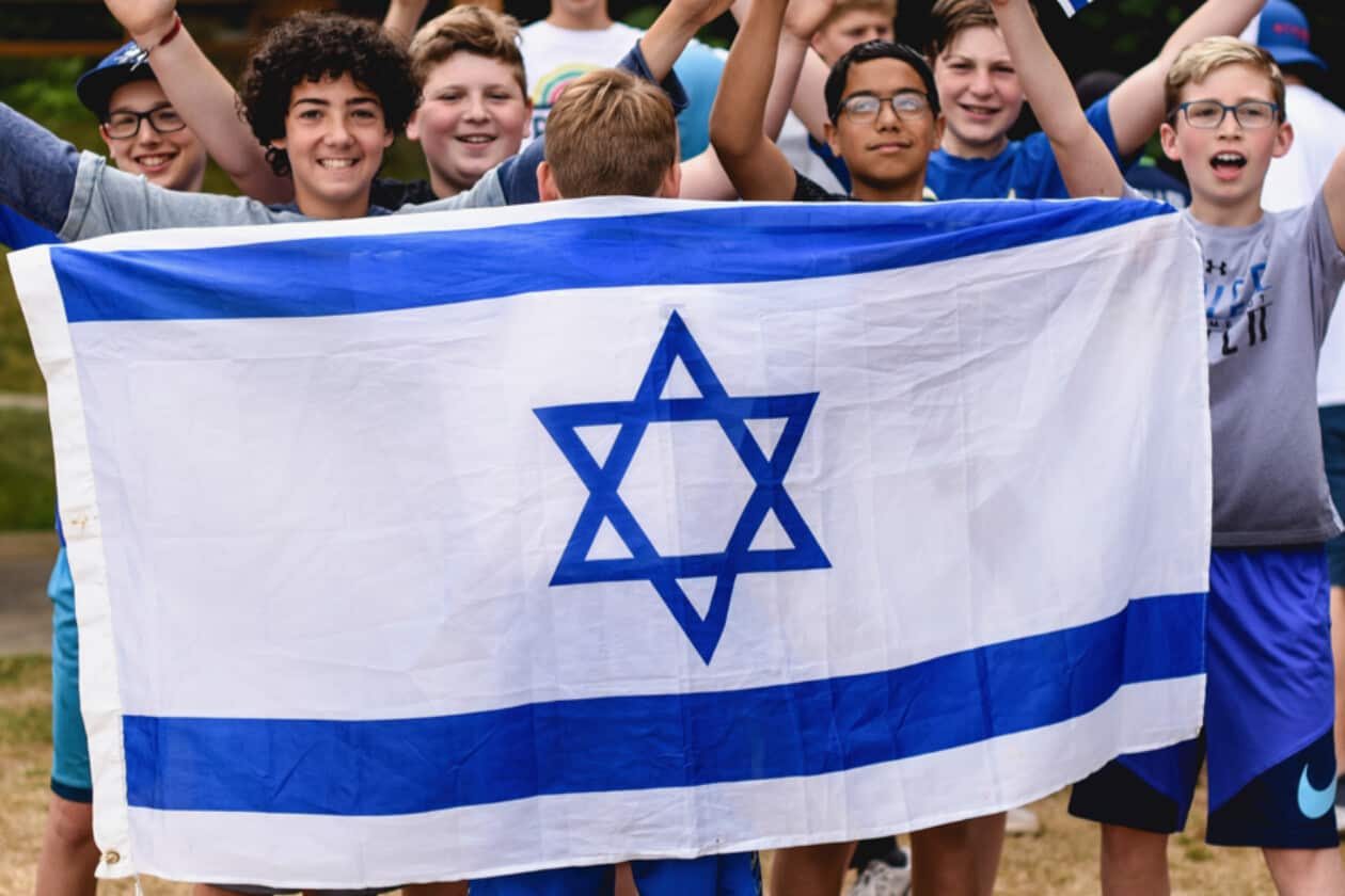 A group of campers with a Israeli flag.
