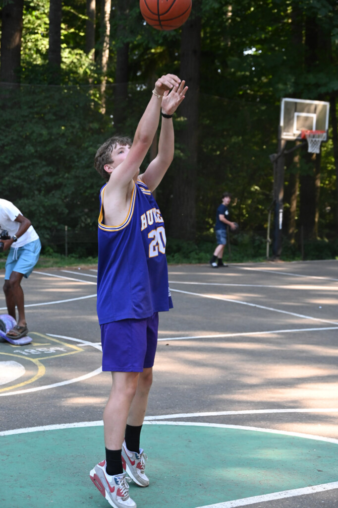 kid shooting basketball in blue jersey.