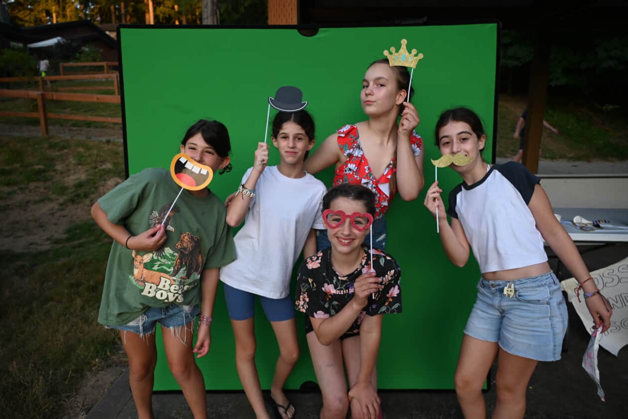 Five campers with photo booth accessories.