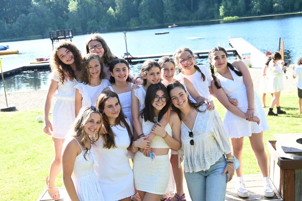 A group of campers all wearing white clothing.