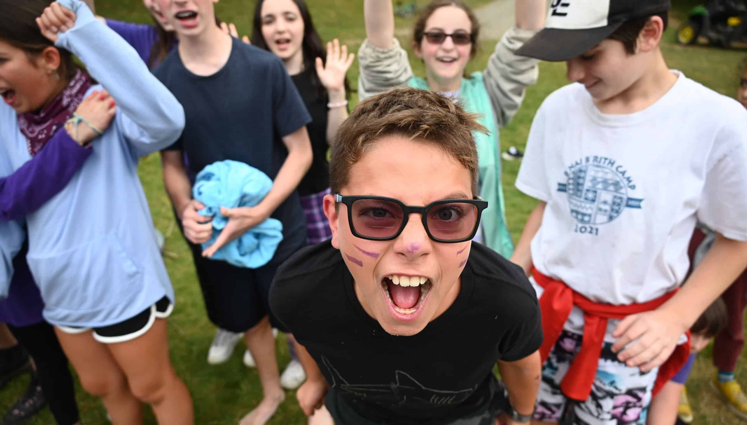 A camper with sunglasses cheering.